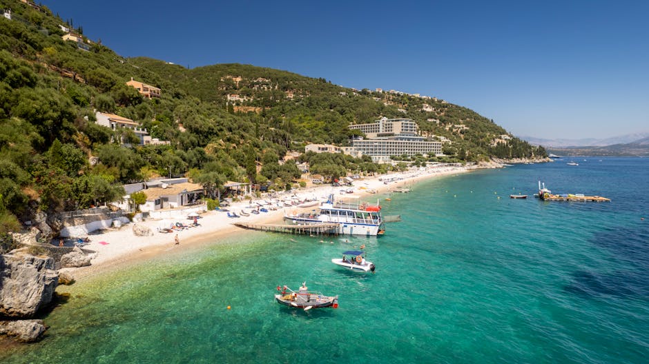 Beautiful aerial view of a beach in Corfu, Greece with turquoise waters and boats.
