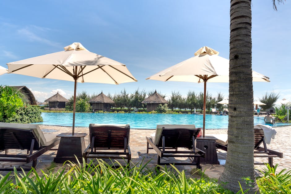 Relax by the pool with lounge chairs and umbrellas at a beautiful tropical resort.
