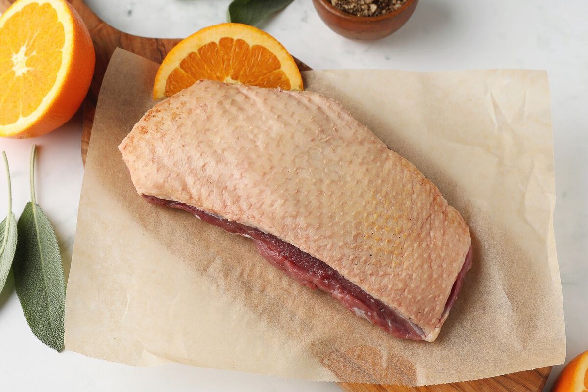 D'Artagnan Moulard duck breast on a board with citrus
