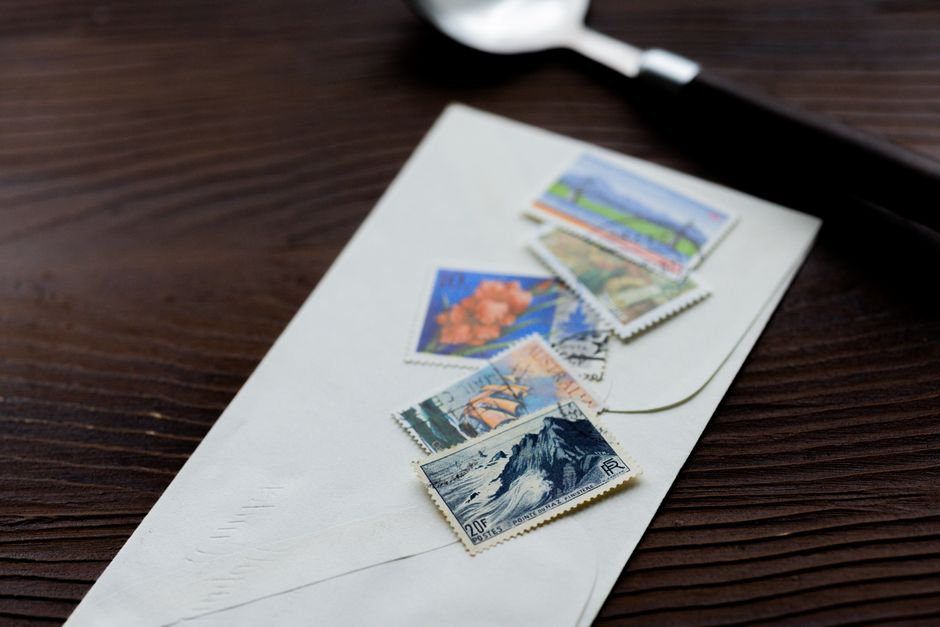 Envelope adorned with vintage stamps on a wooden table, highlighting classic philately.