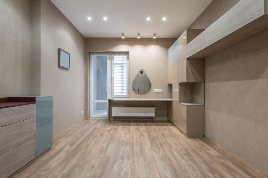 Minimalist design of light room with modern wooden cabinets and table placed near entrance door in stylish apartment at home