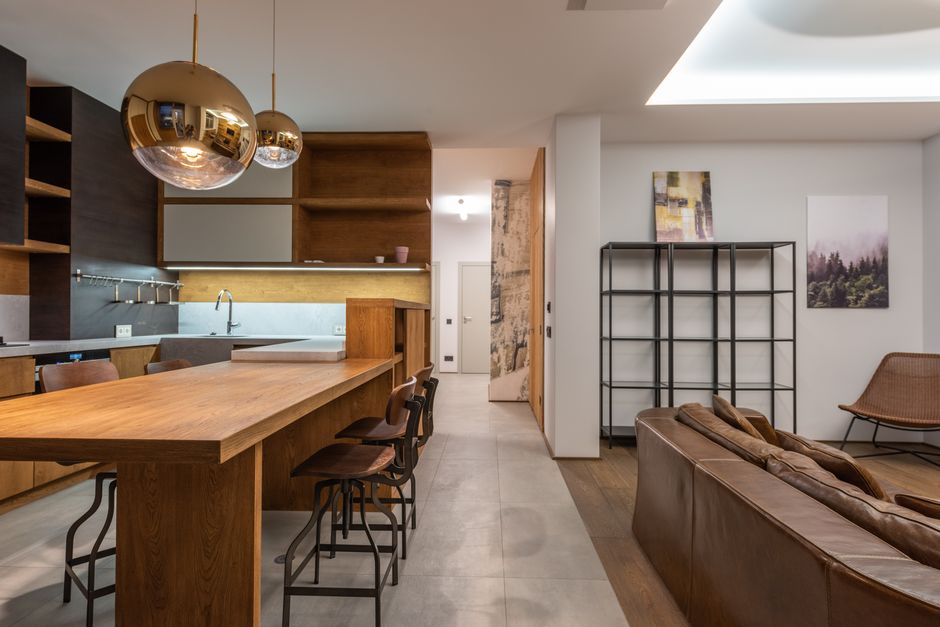 Sleek modern kitchen with wooden furnishings and contemporary decor in open living space.