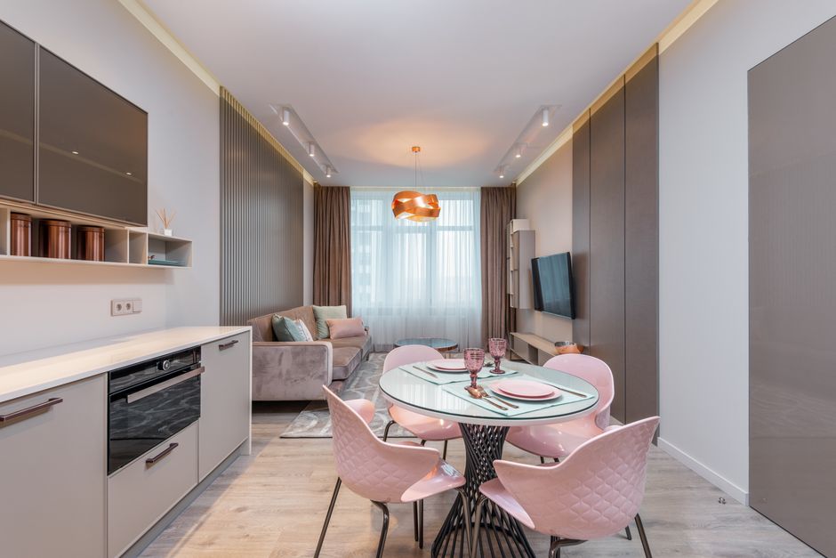 Stylish interior design of contemporary kitchen with dining zone and living room in modern flat