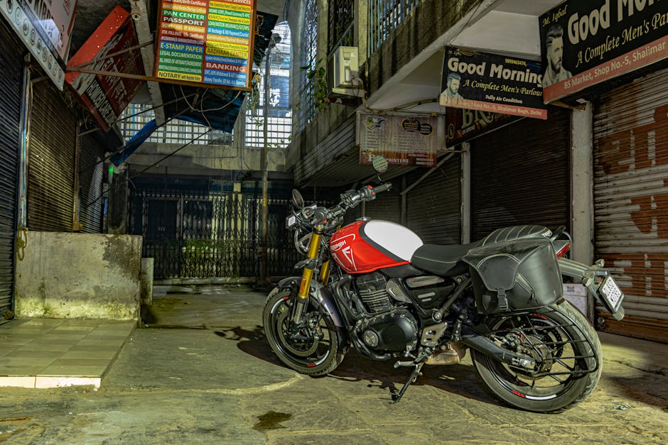 Captivating street view of a red Triumph motorcycle parked in a Delhi alleyway, showcasing urban culture.