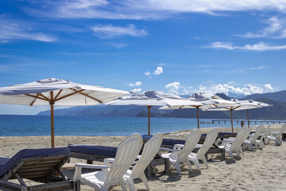 Relaxing beach scene with white umbrellas and chairs in Puerto Cabello, Venezuela.