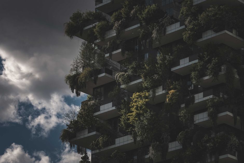 A striking view of a vertical garden on the facade of a modern luxury apartment building under an overcast sky.